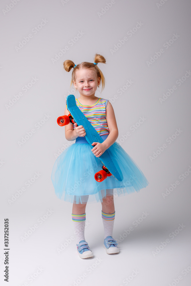 portrait of a little blonde girl smiling holding a skate Board on a white background portrait of a little blonde girl smiling holding a skate Board on a white background