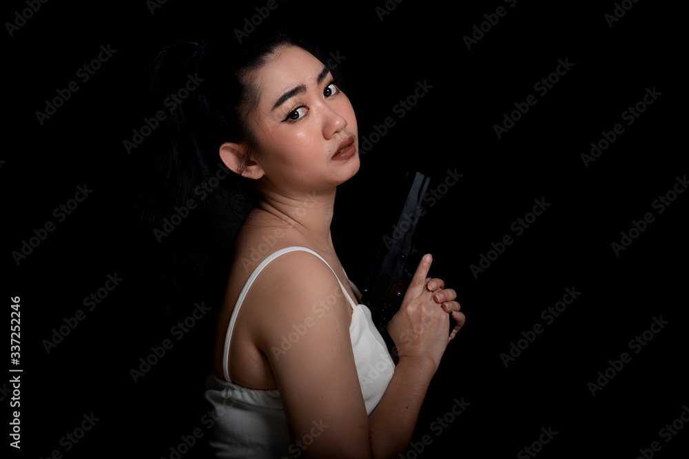 Portrait beautiful Asia woman one hand holding gun at the black background, Young sexy girl long hair with a handgun, Pretty women stand with a pistol, look at camera Portrait beautiful Asia woman one hand holding gun at the black background, Young sexy girl long hair with a handgun, Pretty women stand with a pistol, look at camera
