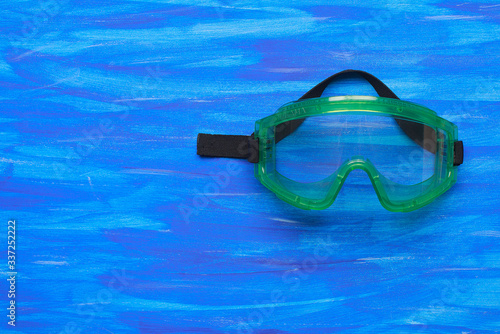 Plastic safety goggles on blue background
