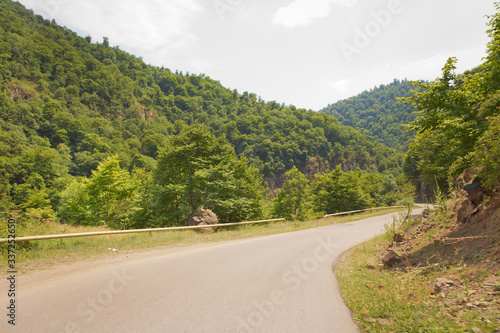 Mountain road between forests . Winding mountain road . A road in Azerbaijan between Forest . Empty road in mountainous area along mountains . highway and mountain with beautiful clouds landscape.