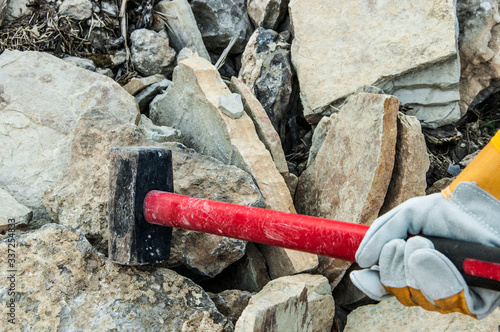 Fotografie big sledgehammer in hand. iron hammer breaking stone into pieces