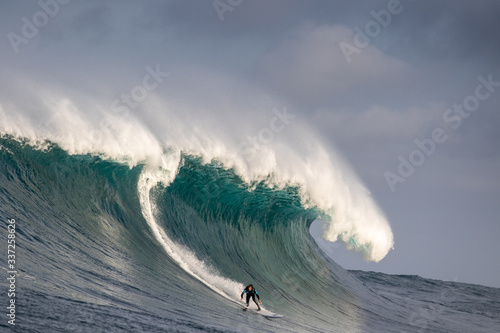 Surfer riding massive wave