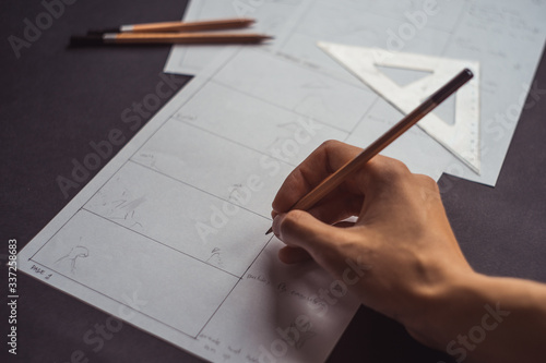 Hands draw a storyboard for the film indoors.