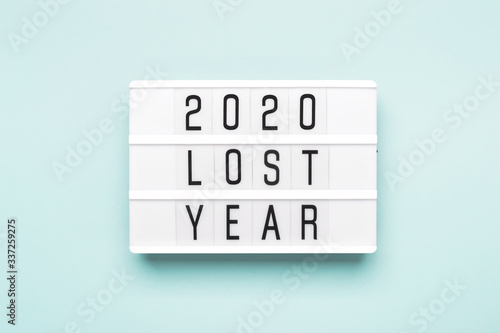 2020 lost year concept. Lightboard with text 2020 lost year on blue paper background