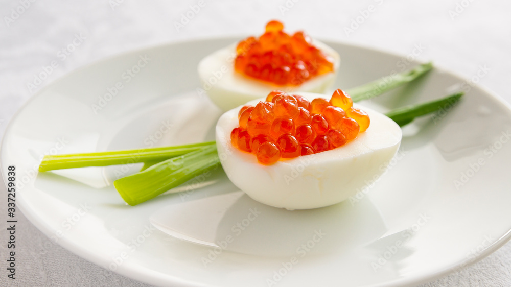 egg halves with red caviar served with green onion egg halves with red caviar served with green onion