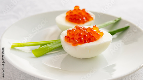 egg halves with red caviar served with green onion