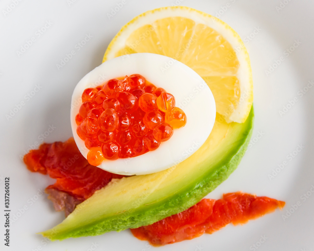 egg with red caviar, chum salmon, lemon, and avocado slices