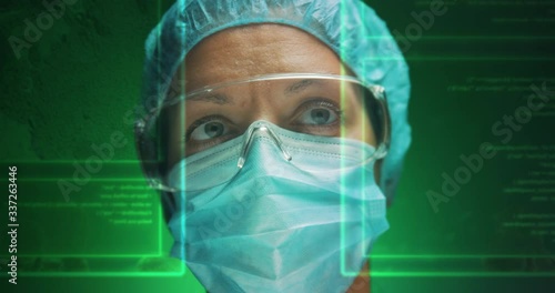 Female surgeon reading from screens in holographic form. Shot on a green background. photo