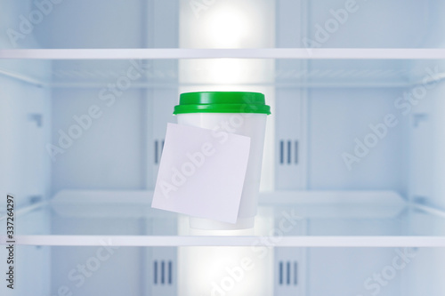 Disposable cup for soup in an empty refrigerator.