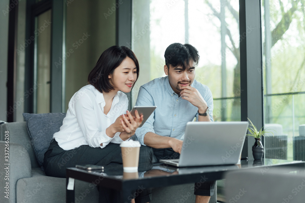 Obraz premium Two young Asian business men and women are working