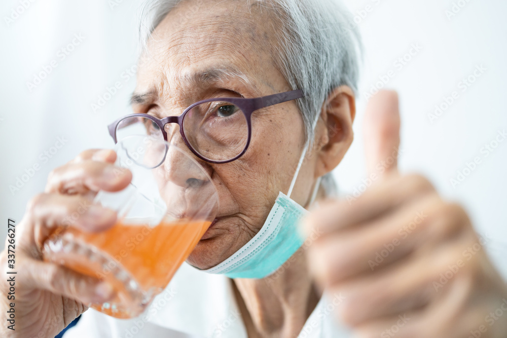 Healthy asian senior woman is drinking a glass of vitamin C or orange juice,elderly people with effervescent vitamin C,strengthening the immunity for cold,flu,fight the Coronavirus,against of Covid-19 Healthy asian senior woman is drinking a glass of vitamin C or orange juice,elderly people with effervescent vitamin C,strengthening the immunity for cold,flu,fight the Coronavirus,against of Covid-19