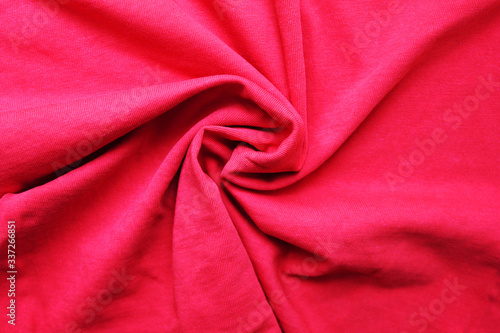 Crumpled red cloth texture background. Wrinkled red fabric material, close up top view of wavy natural colorful cloth material surface. Creasy simple fabric textile of one color