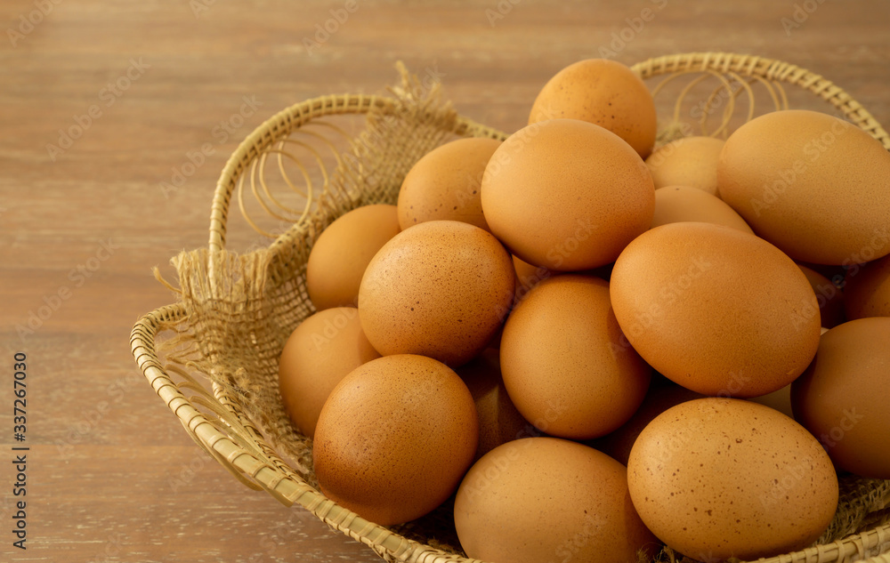 Brown chicken eggs in basket on brown wooden table Brown chicken eggs in basket on brown wooden table