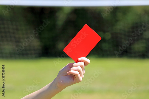 hand holding a soccer red card in a football game.