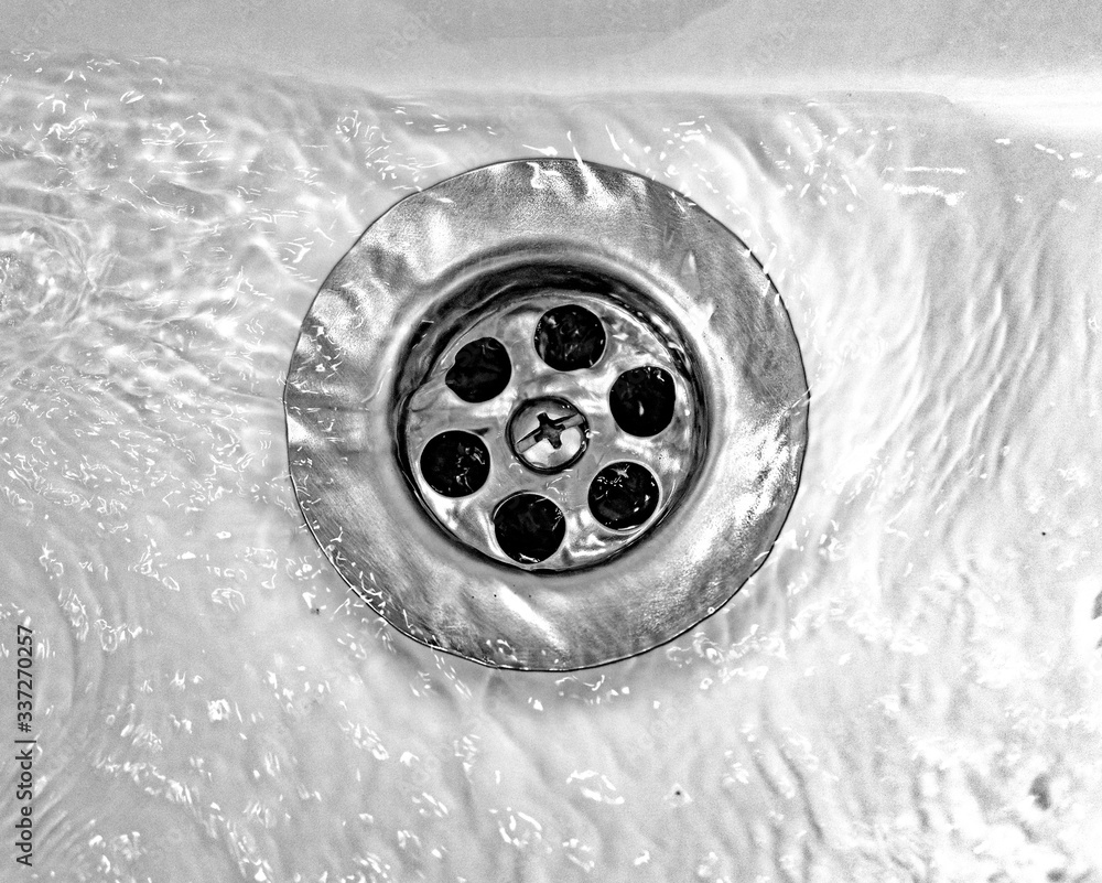 Draining water with a stainless steel grate in an old, long-used bathroom sink Draining water with a stainless steel grate in an old, long-used bathroom sink