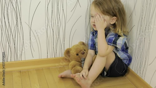 sad little boy sitting on the floor at home  at the day time