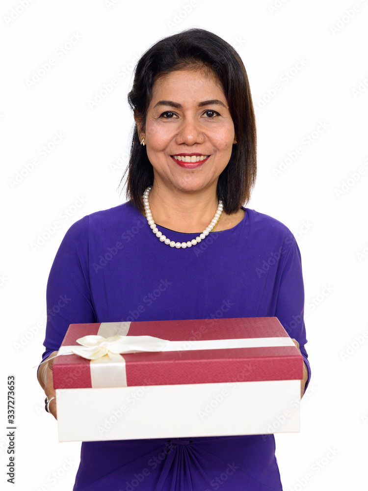 Studio shot of happy mature Asian woman holding gift box isolated against white background Studio shot of happy mature Asian woman holding gift box isolated against white background