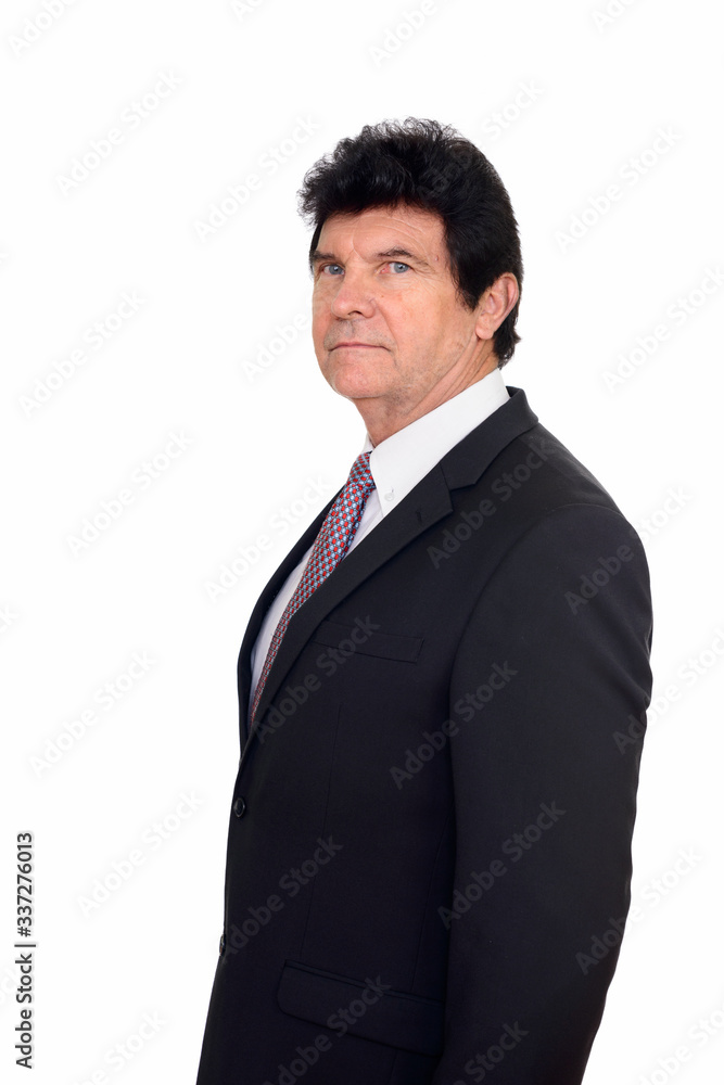 Profile view of mature handsome businessman in suit looking at camera Profile view of mature handsome businessman in suit looking at camera