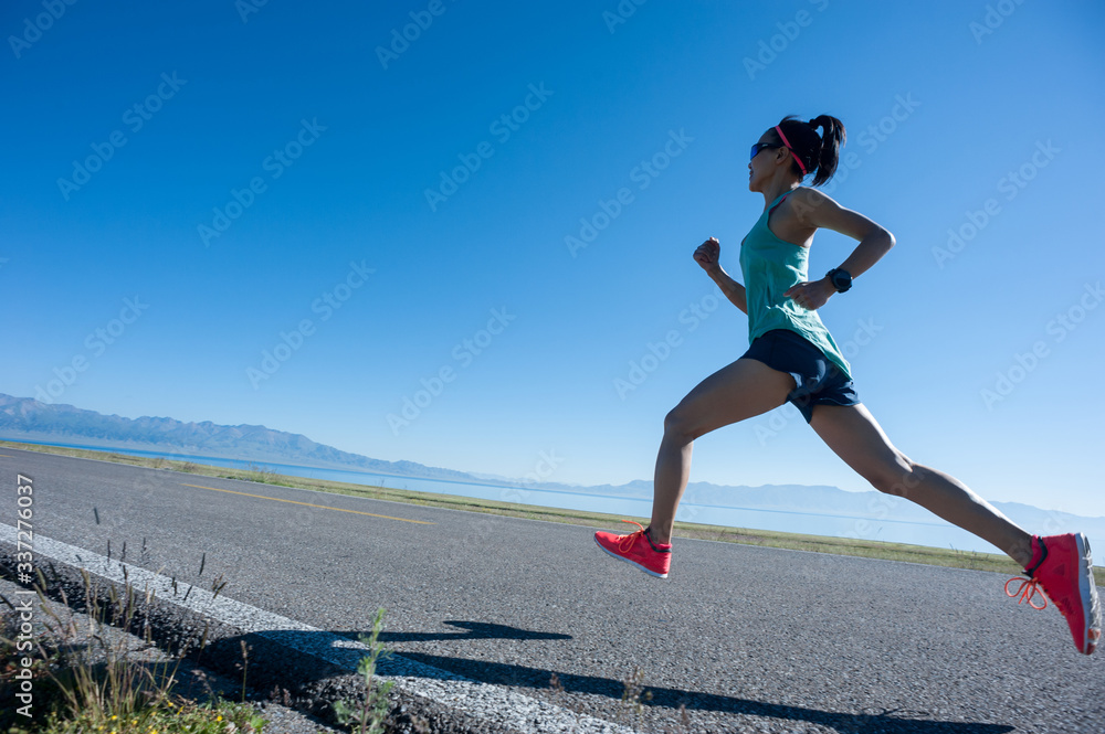 Young fitness woman runner running on sunrise seaside trail Young fitness woman runner running on sunrise seaside trail