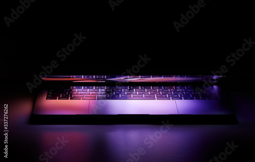 Foto Laptop with Touchbar on dark background, purple light