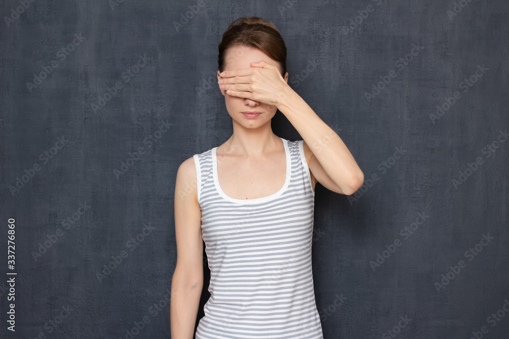 Girl is covering her eyes with hand, not wanting to look at something Girl is covering her eyes with hand, not wanting to look at something
