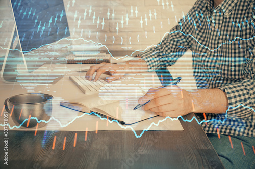 Double exposure of stock market chart with man working on computer on background. Concept of financial analysis.