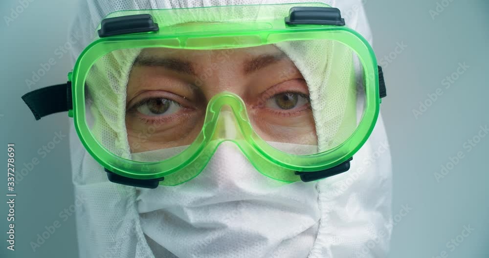 Virologist doctor in protective clothing, green mask looking at the camera Virologist doctor in protective clothing, green mask looking at the camera