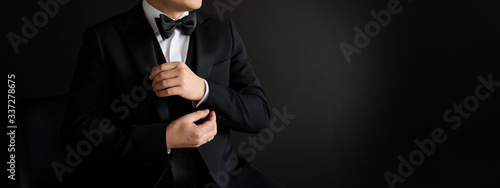 Close up of man who is arranging his black suit