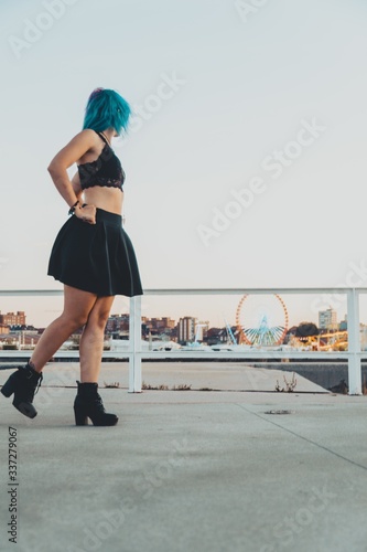 Valokuvatapetti Vertical shot of a young attractive female in a black outfit posing in front of