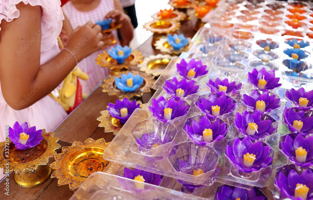 Violet flower candles are on table for buddist take it and respect Buddha statue in temple, Thailand.