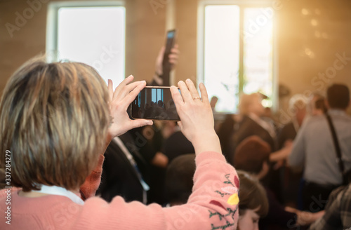 Man at a conference takes pictures using a smartphone photo