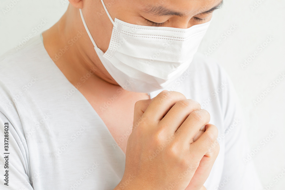 Side view man with medical mask praying safe from disease from coronavirus.Novel coronavirus - 2019-nCoV, WUHAN virus concept. Side view man with medical mask praying safe from disease from coronavirus.Novel coronavirus - 2019-nCoV, WUHAN virus concept.