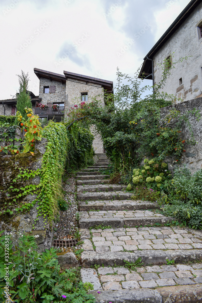 YVOIRE, FRANCE -JUNE 27, 2019- View of a magnificent stone staircase from the medieval village of Yvoire, classified as one of the most beautiful villages in France, Lake Leman in France. YVOIRE, FRANCE -JUNE 27, 2019- View of a magnificent stone staircase from the medieval village of Yvoire, classified as one of the most beautiful villages in France, Lake Leman in France.