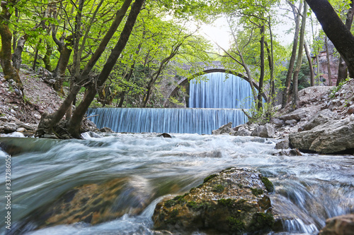 the waterfall of Palaiokaria in Trikala Thessaly Greece - stony arched bridge between the two waterfalls photo