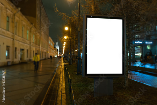Vertical billboard in the city at night. Advertising luminous billboard
