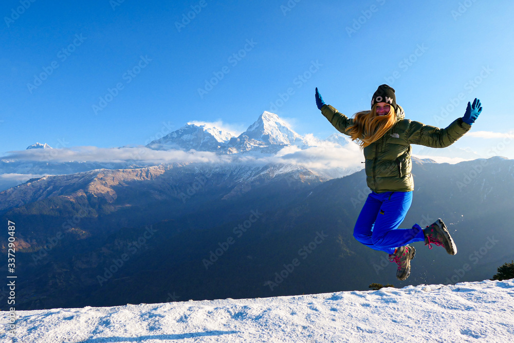 Girl is jumping in front of the mountains. White clouds. Green forest. Girl is jumping in front of the mountains. White clouds. Green forest.