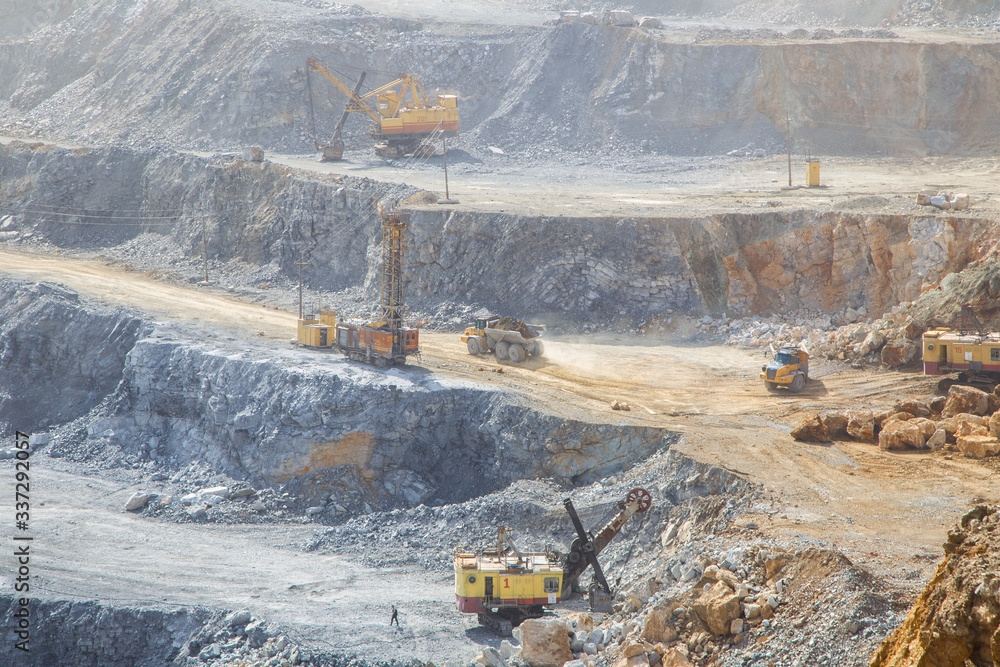 Big open pit magnezite quarry mine with working drilling machines, excavators, trucks Big open pit magnezite quarry mine with working drilling machines, excavators, trucks