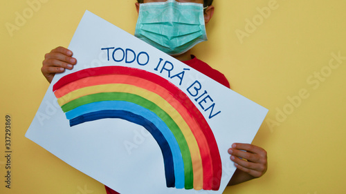 Child with medical mask and rainbow message in Castellano Spanish photo