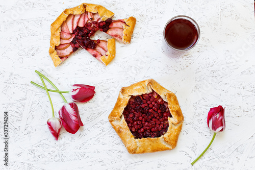 Homemade Galle pastries with berries, berry tea, compote on a white background