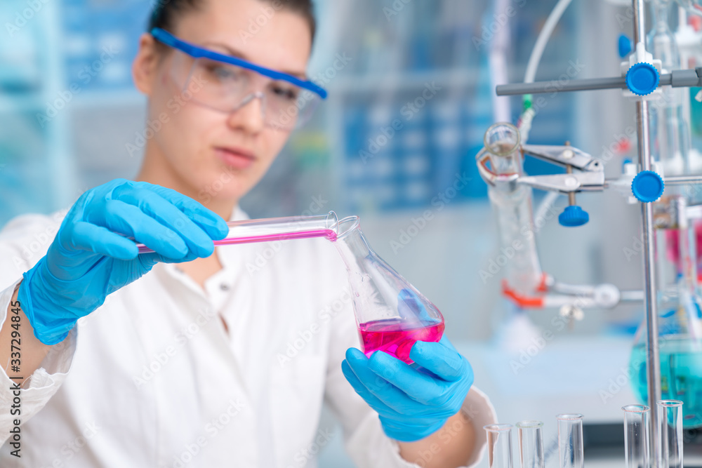 Fototapeta premium Young woman in a pharmacological laboratory. Development of an antiviral drug. Pandemic COVID-19
