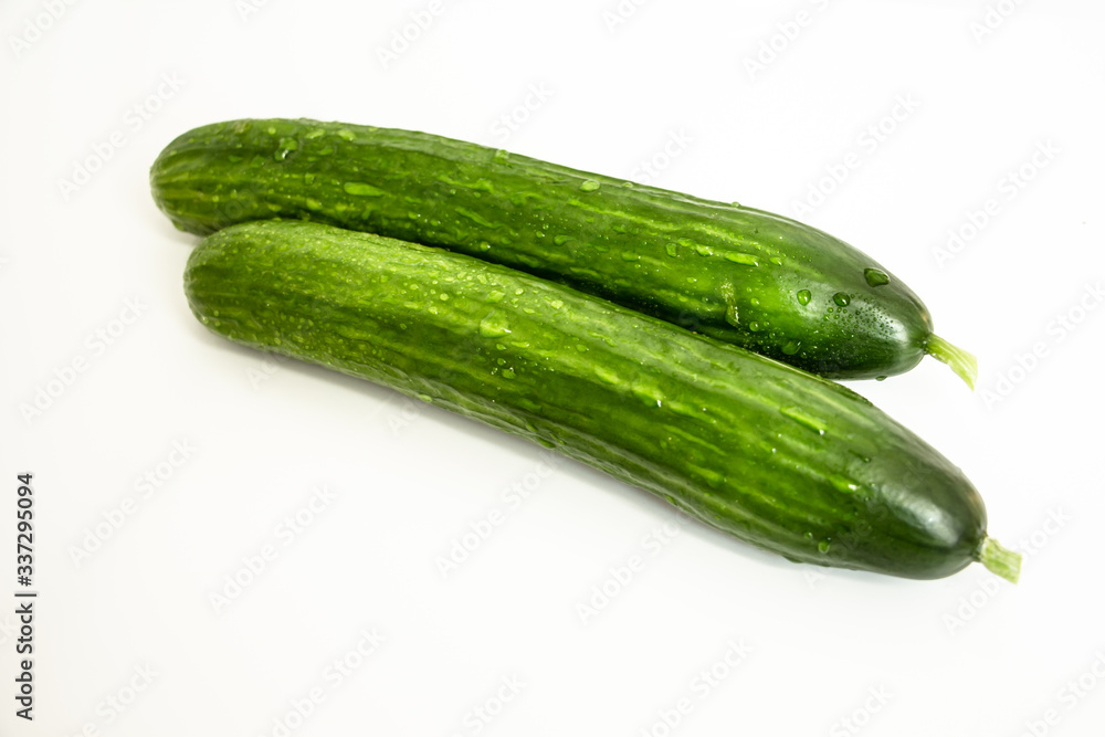 two juicy green cucumbers on a white background close-up two juicy green cucumbers on a white background close-up
