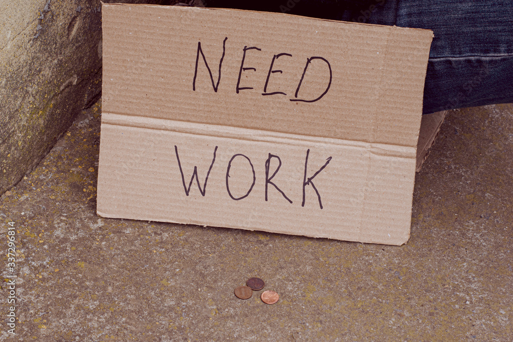 Obraz premium cardboard plate next to unemployed sitting on concrete with need work coins lie nearby on a ground