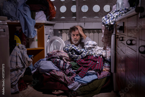 Desperate middle-aged man, not knowing how to use a washing machine 