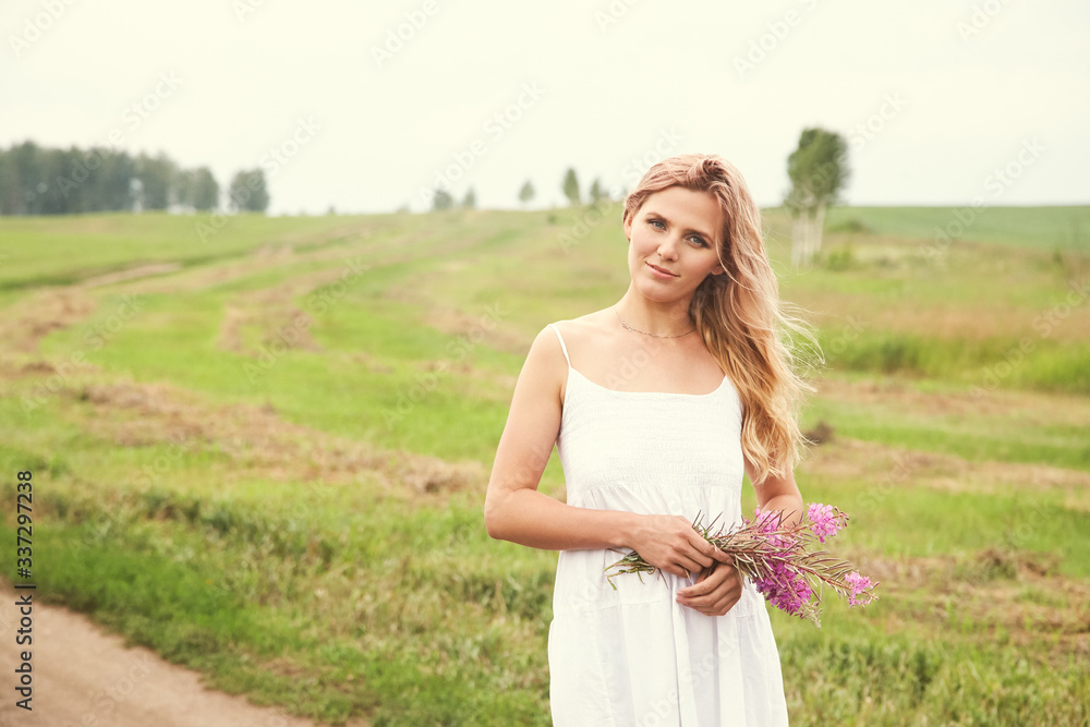outdoor portrait of a beautiful middle aged blonde woman in a field with flowers. outdoor portrait of a beautiful middle aged blonde woman in a field with flowers.