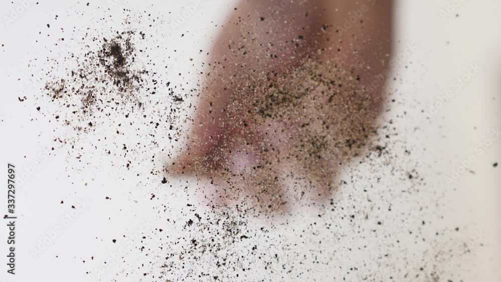 Slow motion unique perspective of a hand sprinkling ground pepper down onto glass. Slow motion unique perspective of a hand sprinkling ground pepper down onto glass.