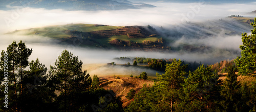 Beautiful, colorful autumn panorama of Pieniny Mountains (polish: Male Pieniny) and Tatra Mountains in the fog and morning light, Poland, Slovakia