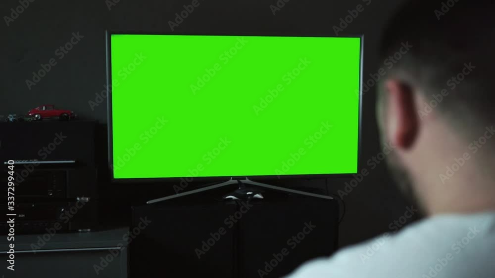 Bearded Caucasian man watching widescreen TV at home. Chroma key Bearded Caucasian man watching widescreen TV at home. Chroma key