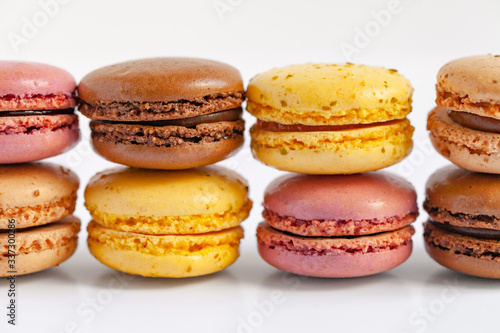 Assortment of delicious traditional french macaroons. Colorful sweet dessert for real gourmands. Lemon, chocolate, caramel, raspberry flavors. White background, copy space, close up, macro, isolated