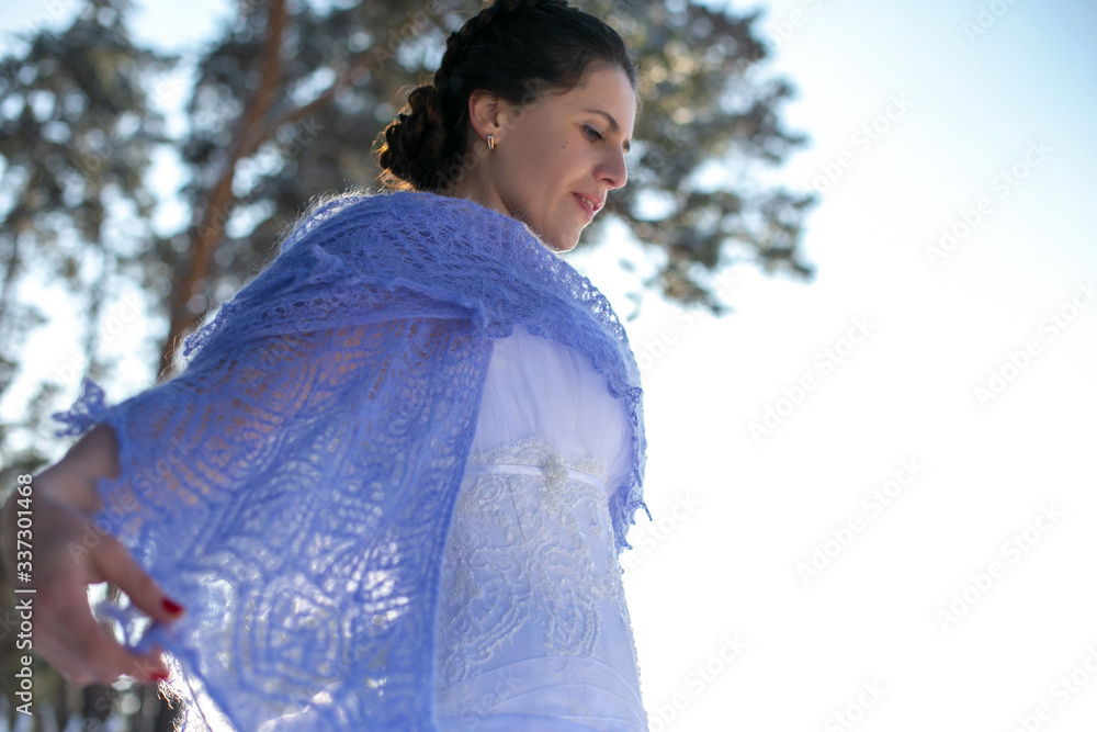 horizontal closeup photo of a beautiful brunette in a lilac shawl against a background of pines and a winter sky horizontal closeup photo of a beautiful brunette in a lilac shawl against a background of pines and a winter sky