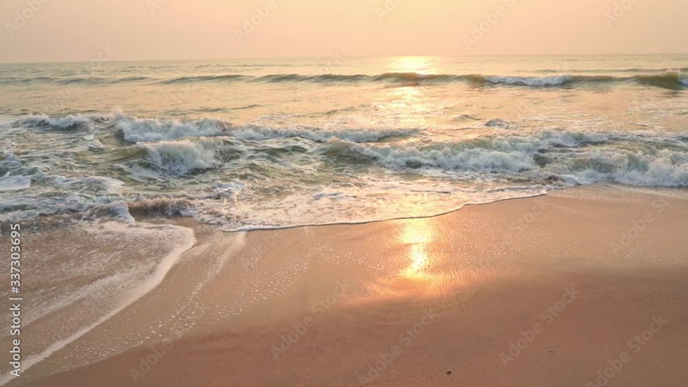 Soothing waves of Hua Hin beach Thailand at sunset in slow motion 